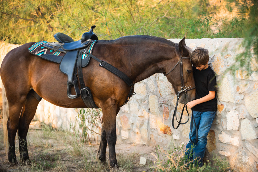 Equine photographers capture special moments like this - a boy cuddling with his horse in front of a rock wall in El Paso, Texas. 