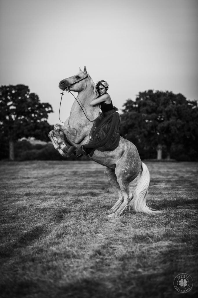 Black and white photograph of a woman riding a rearing horse.  Question to ask your photographer - do you carry liability insurance?
