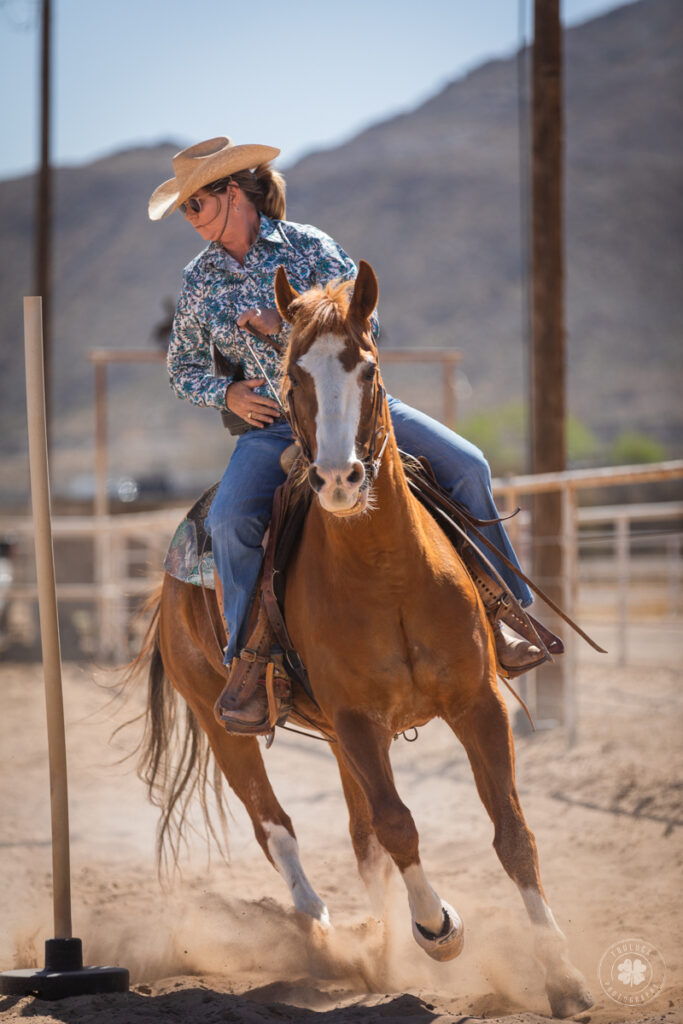 Photograph of a cowgirl riding a horse around poles in El Paso, Texas for a horse show. 