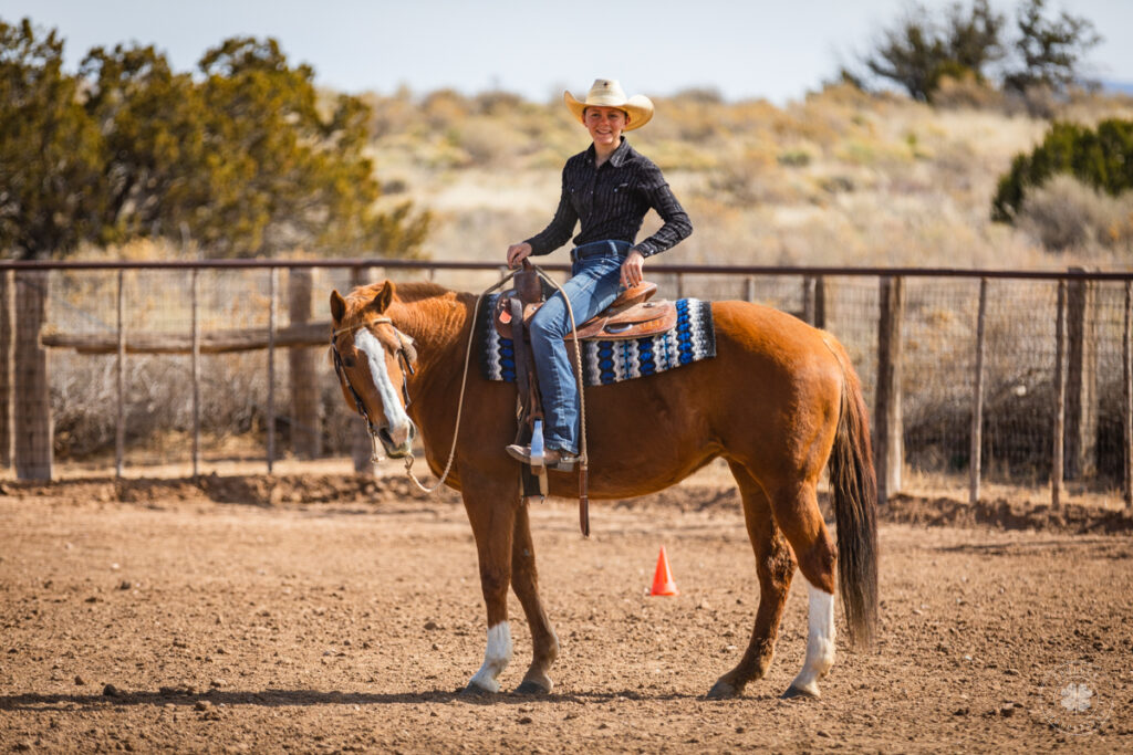 Photograph of a cowgirl riding a chestnut horse for a western pleasure class in Santa Fe, New Mexico. 