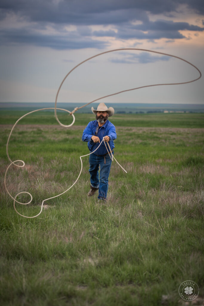 Photograph of a cowboy throwing a rope at the photographer.  
