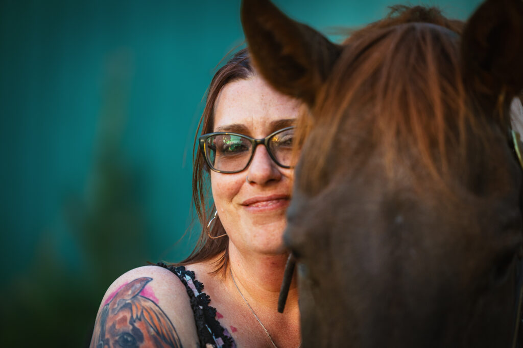 photograph of a woman's face next to her chestnut horse's face.